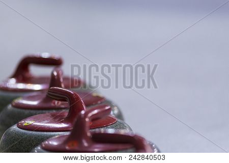 Sport Ideas And Concepts. Closeup Of Curling Red Handle Stones On Ice.with Copy Space. Horizontal Im