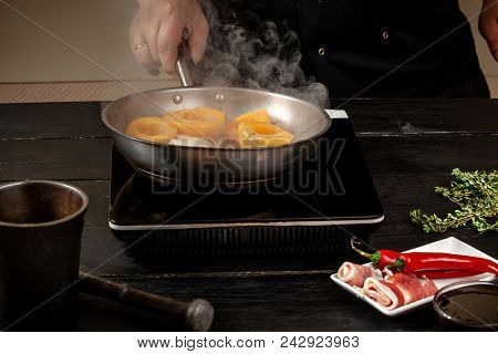 Chef Cook Peaches On A Fry Pan. Canned Fruit Yellow Peaches, Black Wooden Background, Board, In The 