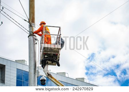 Electrician Climbing Work In The Height On Concrete Electric Power Pole And Basket With Big Crane On