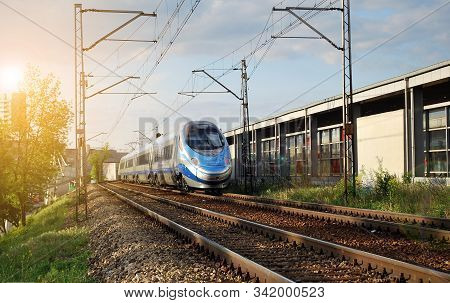 Train On The Railroad Tracks During Sunset. Perron At The Train Station.