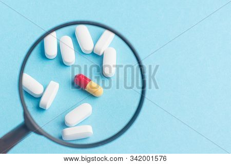 Concept - Pharmaceutical Testing, Testing Of Medicines, Magnifying Glass, Tablets On A Blue Backgrou