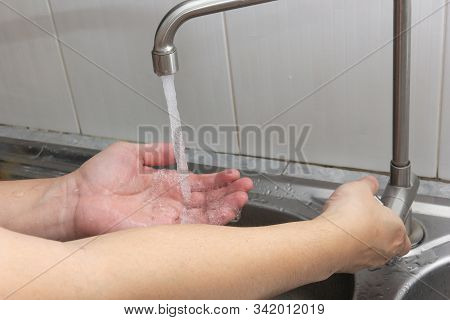 The Hand That Is Turning On The Water And The Other Hand Is Getting The Water.hygiene Concept.