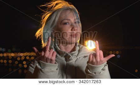 Fuck Off. Bad Girl Showing Fuck Sign At Camera. Night Outdoor Shot
