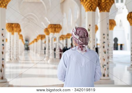 Arab Man Visiting The Grand Mosque In Abu Dhabi Wearing Traditional Dress Back View