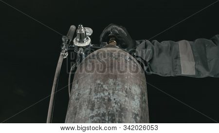 Forge Workshop. Smithy Manual Production. A Worker Open Gas Cylinder Vessel With Oxygen For Welding.