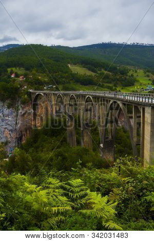 Djurdjevica Bridge Is A Concrete Arch Bridge Over The Tara River Canyon, Mountains And Forests Aroun
