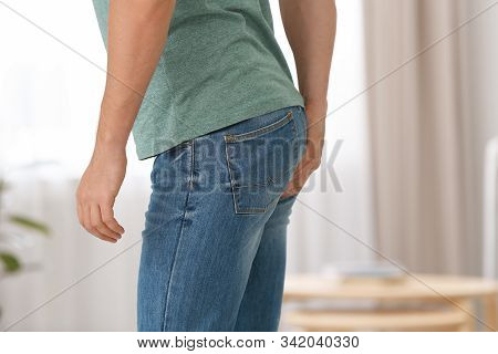 Man Suffering From Hemorrhoid At Home, Closeup