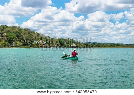 El Remate, Peten, Guatemala - 29 May 2019: Fisherman In Canoe Boat In Turquoise Colored Lake Itza Ro