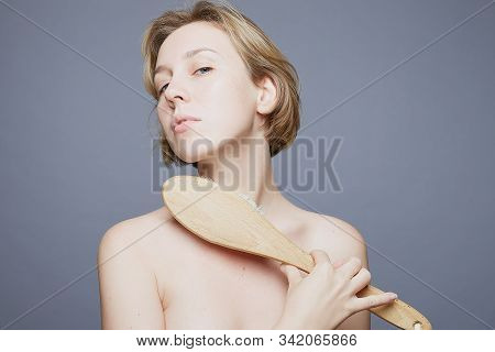 Beautiful Caucasian Blond Woman With Blue Eyes Making Scrub Body Massage With Big Brush. Woman Dry B