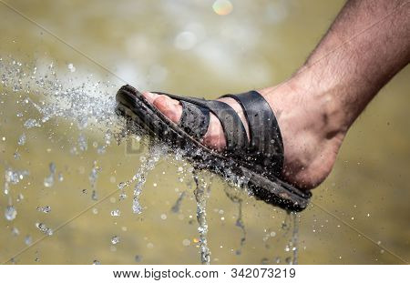 The Foot Of A Man In The Spray Of Water Of The Fountain In Summer.