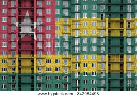 Togo Flag Depicted In Paint Colors On Multi-storey Residental Building Under Construction. Textured 