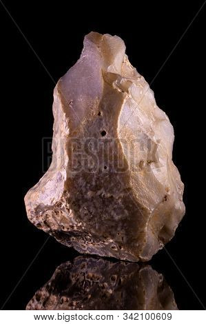 Ancient Stone Hand Ax. Paleolithic Period. Black Background.