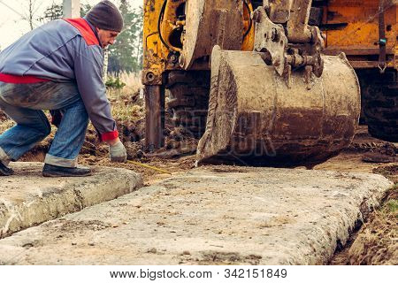 The Excavator Installs Concrete Slabs For The Road.