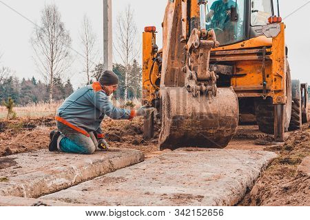 The Excavator Installs Concrete Slabs For The Road.