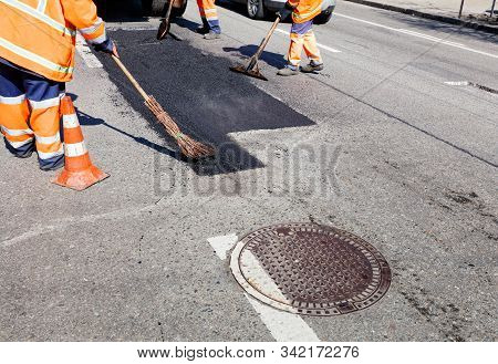 When Repairing The Road, The Working Team Pours Hot Asphalt Onto Even Patches With Shovels, A Level 
