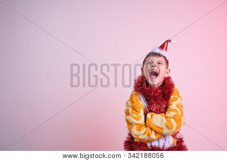 Excited Happy Laughing Child, Boy In Red Santa Hat Dressed In Giraffe Pajamas And Wrapped In Red New