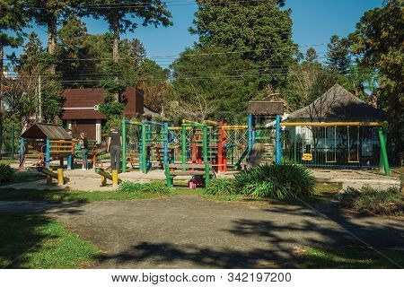 Gramado, Brazil - July 21, 2019. Colorful Playground Equipment Among Trees With Children And Adults 