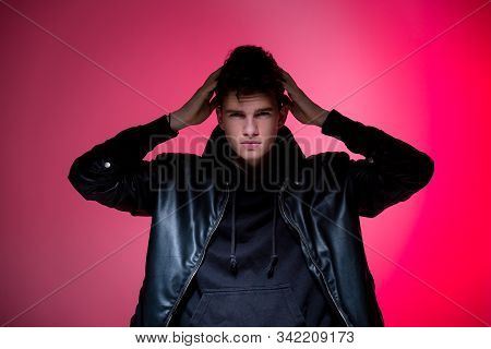 Cute Brutal Man In Black Leather Jacket Model Style. Portrait Of A Handsome Guy On Pink Studio Backg