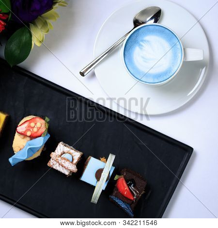 Cup Of Vegan Blue Latte And Small Treats. Concept Of Trendy Coffeine Free Vegan Refreshment Break. T