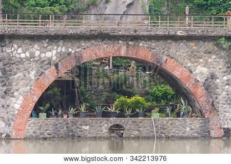 Bridge Of A Devil. Bridge Over The River In Tuscany. Built In The 11 Century. Pots With Plants Under