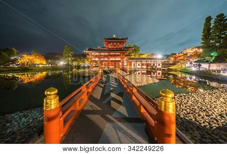 Byodoin Temple Pagoda And Lake With Red Maple Leaves Or Fall Foliage In Autumn Season. Colorful Tree