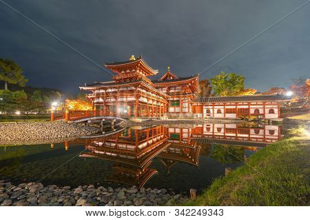 Byodoin Temple Pagoda And Lake With Red Maple Leaves Or Fall Foliage In Autumn Season. Colorful Tree