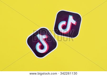 Tiktok Paper Logo On Yellow Background. Tiktok Is A Popular Video-sharing Social Networking Service 