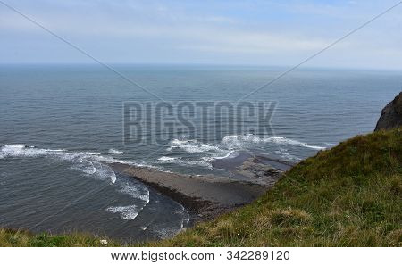 Rock Jetty With Waves Crashing Around It In England.