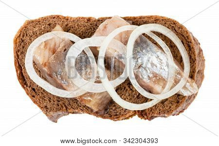 Top View Of Open Sandwich With Rye Bread And Pickled Herring Decorated Of Onion Rings Isolated On Wh
