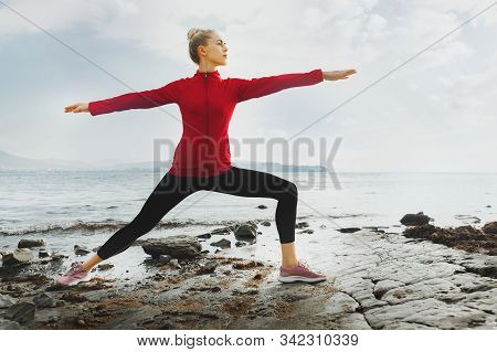 Young Attractive Woman Practicing Yoga On The Beach. Biohacking, Meditation, Mental Health Concept