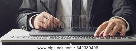 Wide View Image Of Businessman Or Graphic Designer Using A Stylus Pen And Tablet While Typing On His