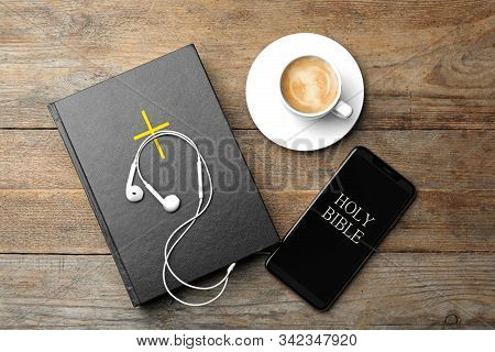 Bible, Phone, Cup Of Coffee And Earphones On Wooden Background, Flat Lay. Religious Audiobook