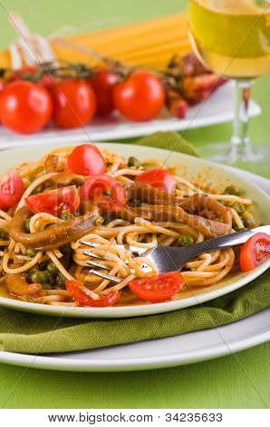 Spaghetti with squids peas and cherry tomatoes.
