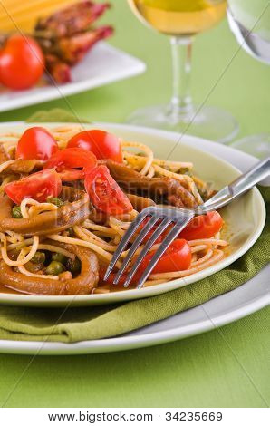 Spaghetti with squids peas and cherry tomatoes.