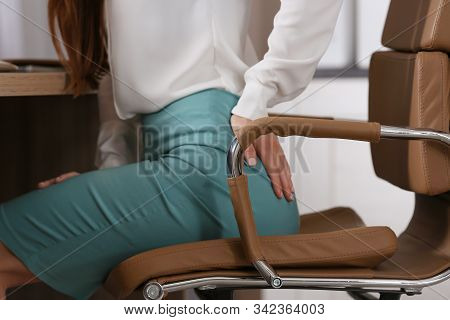 Young Woman Suffering From Hemorrhoid At Workplace, Closeup