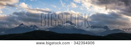 Striking And Dramatic Panoramic Canadian Landscape View Of The Mountain Peaks During A Cloudy Sunset