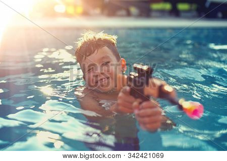 Little Kid Targeting With Suction Cup Gun Toy In Swimming Pool, Summer Holiday
