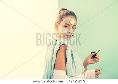 Attractive Healthy Girl With Natural Mask And Slices Of Fresh Cucumber At Face Take Care Of Her Skin