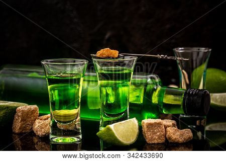 Absinthe Shots With Sugar Cubes. Absinthe Poured Into A Glass. Bottle Of Absinthe With Brown Sugar A