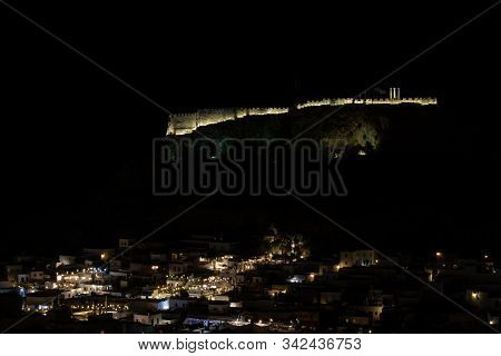 View At The Illuminated City Of Lindos And The Acropolis On Greek Island Rhodes By Night