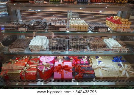 Close Up Of Several Chocolate Sweets In A Shop. Chocolate Candy In A Store Window. Stand With Chocol