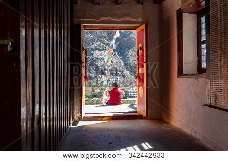 Young Novice Monk Sitting Outside Buddhist Temple