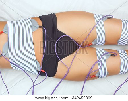 The Procedure Of Myostimulation On The Legs And Buttocks Of A Woman In A Beauty Salon. Overweight Tr