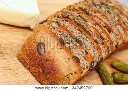Pre-sliced Rye And Wheat Bread With Pumpkin Seeds On Kitchen Board