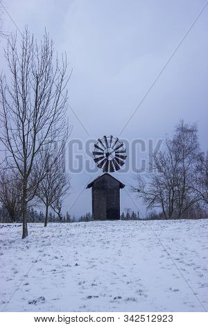 Snowy Landscape In Winter With Tree With Mistletoe In Foreground And With Retro Windmill In Backgrou
