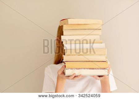 Teenage Girl Hiding Behind Big Pile Of Books She Wants To Read. Student Ready To Study Concept