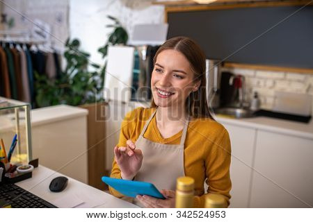 Attentive Cafe Employee Using The Tablet For Taking Order