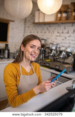 Smiling Barista Taking Orders Online Using The Tablet