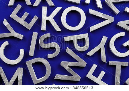 Abstract Flat Background Of Silver Metal English Alphabet Characters On Phantom Blue Background.