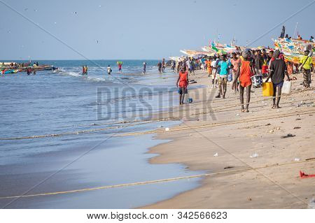 Tanji, The Gambia - November 21, 2019: Scene With Men And Women Carrying Fish From The Boats To The